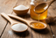 A spoon of table sugar and a spoon of honey
